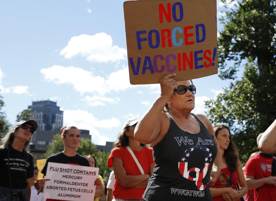 A QAnon supporter protests against Massachusetts Gov. Charlie Baker's order for mandatory influenza vaccinations for all students under age 30, in Boston on Aug. 30, 2020. (Jessica Rinaldi/The Boston Globe via Getty Images)