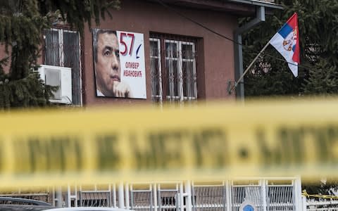 A poster bearing a picture of Oliver Ivanovic hangs on the wall of his offices after he was killed in a brazen drive-by shooting in Mitrovica  - Credit: ARMEND NIMANI/AFP/Getty Images