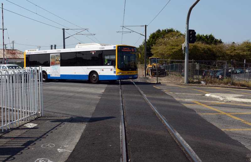 A Translink bus crosses a level crossing in Brisbane.