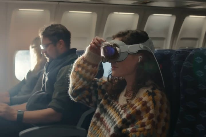 A person wears an Apple Vision Pro headset on an airline flight.
