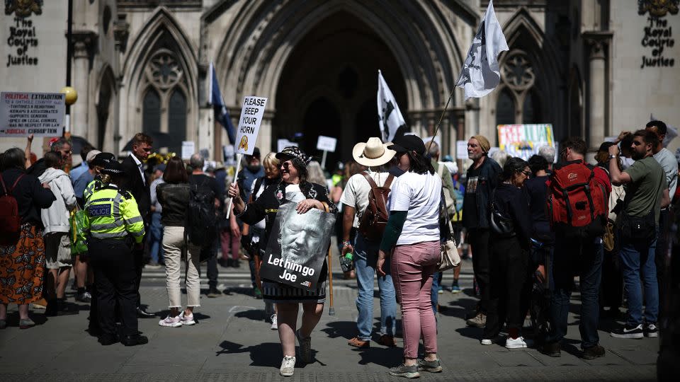 An Assange supporter pictured with a placard reading "Let him go Joe" outside London's Royal Courts of Justice. - Henry Nicholls/AFP/Getty Images