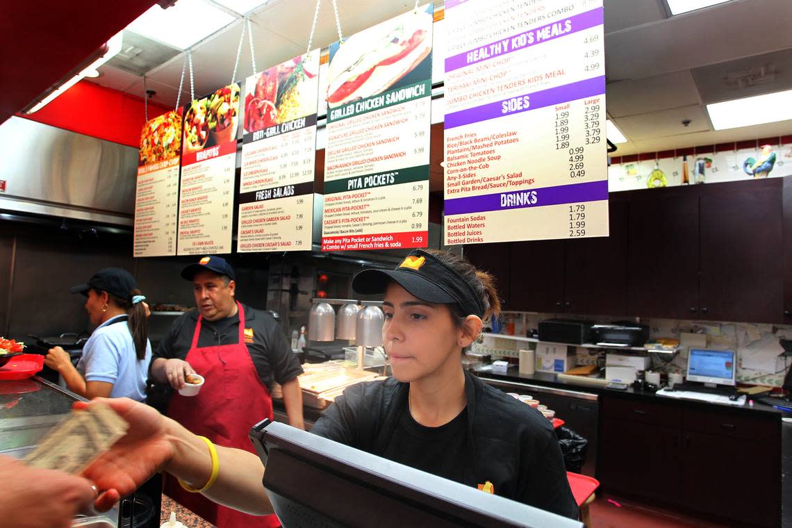 Lara Torres takes money from a customer at Chicken Kitchen in the food court at the Aventura Mall on June 24th, 2010.