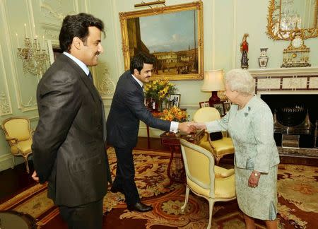 Britain's Queen Elizabeth shakes hands with, Sheikh Joaan bin Hamad al-Thani, brother of the Emir of Qatar, Sheikh Tamim bin Hamad al-Thani (L), during a private audience, at Buckingham Palace in central London October 29, 2014. REUTERS/John Stillwell/Pool