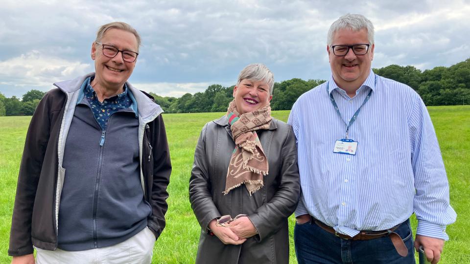 Mick Emerson, Lee House, Jon Hogan. All three are smiling at the camera - Mr Emerson is wearing glasse, a grey jacket over a blue underjacket which is over a spotted blue shirt and has short light hair. Ms House has a black coat on with a brown scarf while Mr Hogan has a blue pin-striped shirt on with jeans and a lanyard around his neck and his hair is short and white