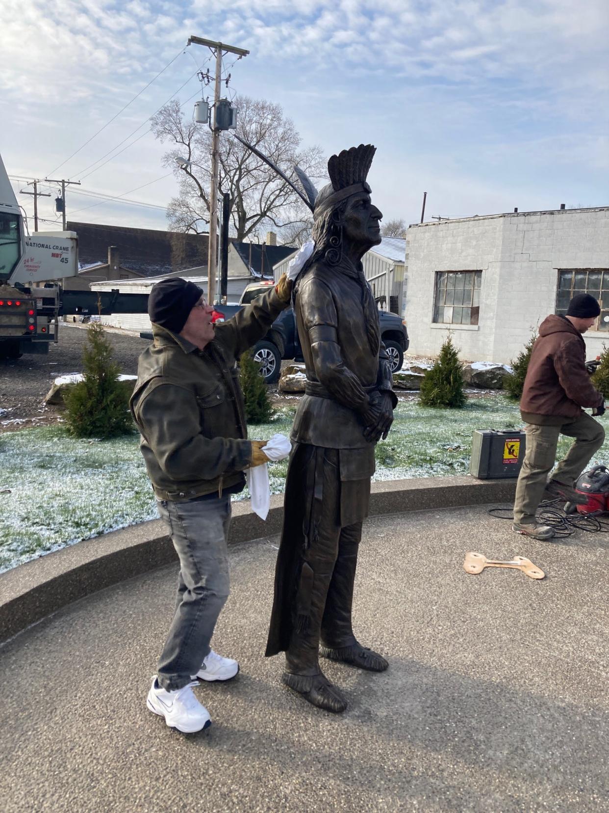 Alan Cottrill, a sculptor from Zanesville, puts the final polishing touches on the Chief Netawatwees sculpture placed outside the Temperance Tavern Museum on Canal Street in Newcomerstown