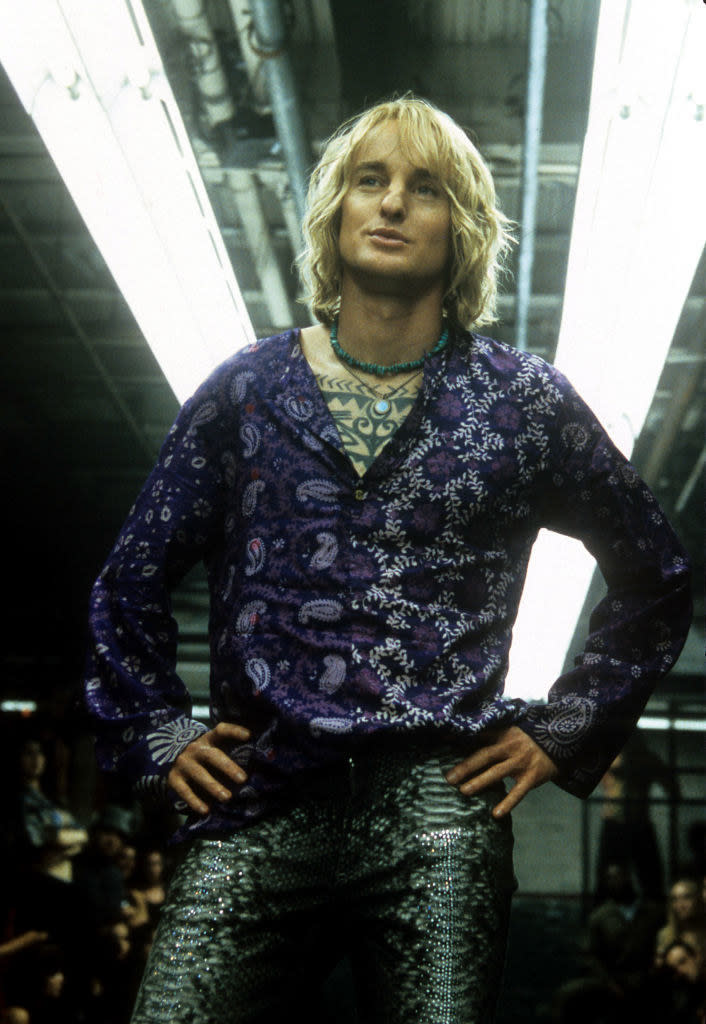 Owen Wilson with his hands on his hips wearing a paisley shirt and snakes skin pants in a scene from the film 'Zoolander'