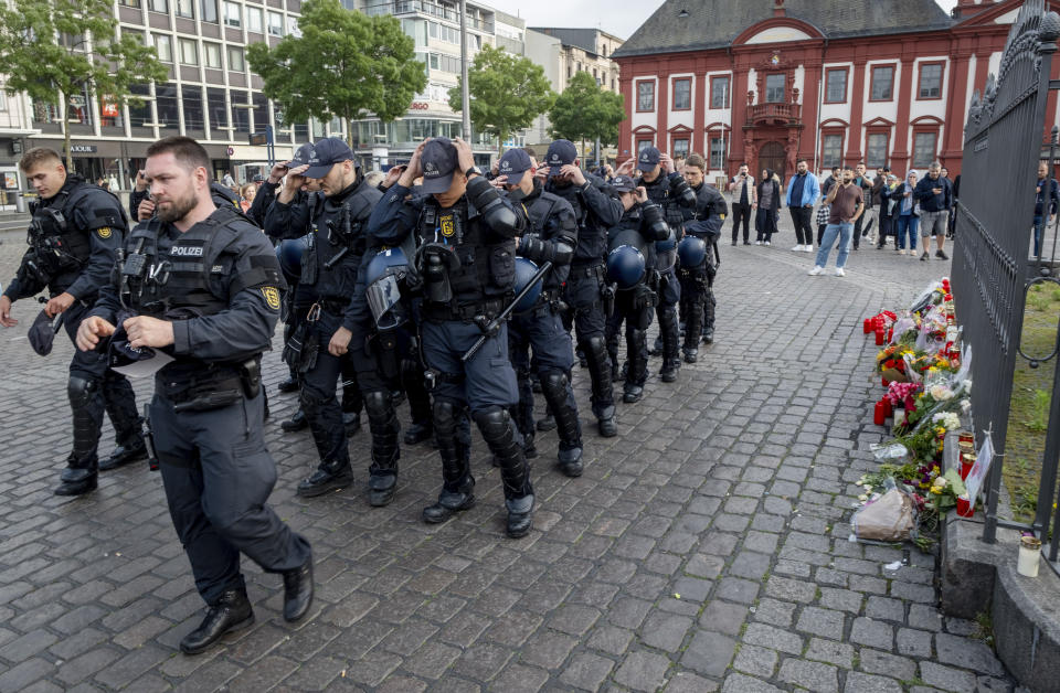 German police officers commemorate a colleague in Mannheim Germany, after learning that a police officer, who was stabbed two days ago there has died on Sunday, June 2, 2024. (AP Photo/Michael Probst)