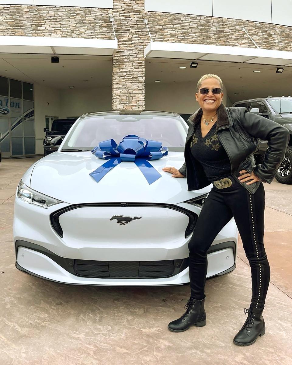 Dr. Sian "Leo" Proctor, a SpaceX astronaut, with her Ford Mustang Mach-E wrapped with a blue ribbon in December 2021.