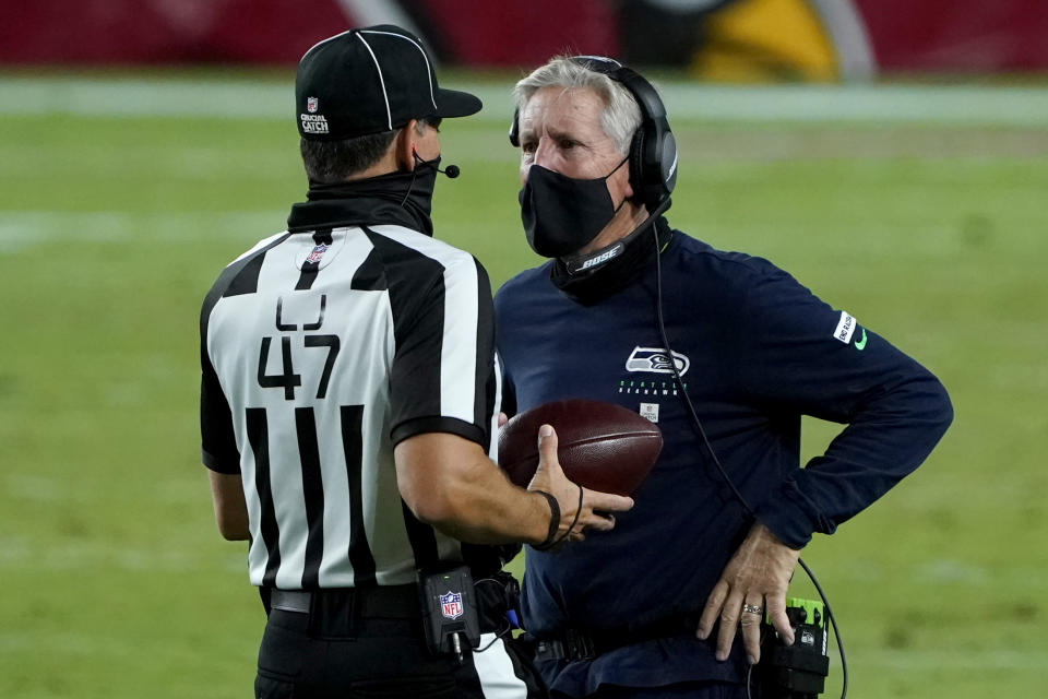 El entrenador en jefe de los Seahawks de Seattle Pete Carroll habla con el juez de línea Tim Podraza durante el encuentro ante los Cardinals de Arizona el 25 de octubre dle 2020. (AP Foto/Rick Scuteri)