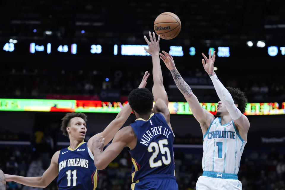 Charlotte Hornets guard LaMelo Ball (1) attempts a 3-point shot abasing New Orleans Pelicans guard Trey Murphy III (25) and guard Dyson Daniels (11) in the first half of an NBA basketball game in New Orleans, Wednesday, Jan. 17, 2024. (AP Photo/Gerald Herbert)