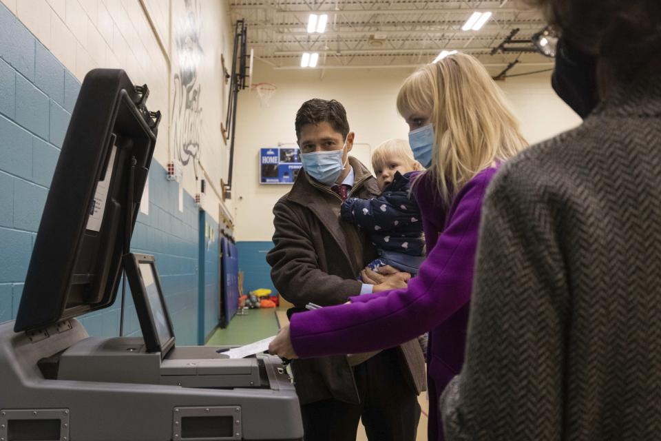 Mayor Jacob Frey casts his vote on Election Day alongside his family at the Marcy Arts Magnet Elementary School on Tuesday, Nov. 2, 2021 in Minneapolis. Voters in Minneapolis are deciding whether to replace the city’s police department with a new Department of Public Safety. The election comes more than a year after George Floyd’s death launched a movement to defund or abolish police across the country. (AP Photo/Christian Monterrosa)