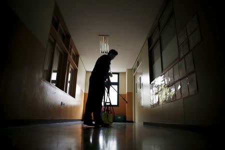 An employee from a disinfection service company stands in the corridor at an elementary school in Seoul, South Korea, June 11, 2015. REUTERS/Kim Hong-Ji