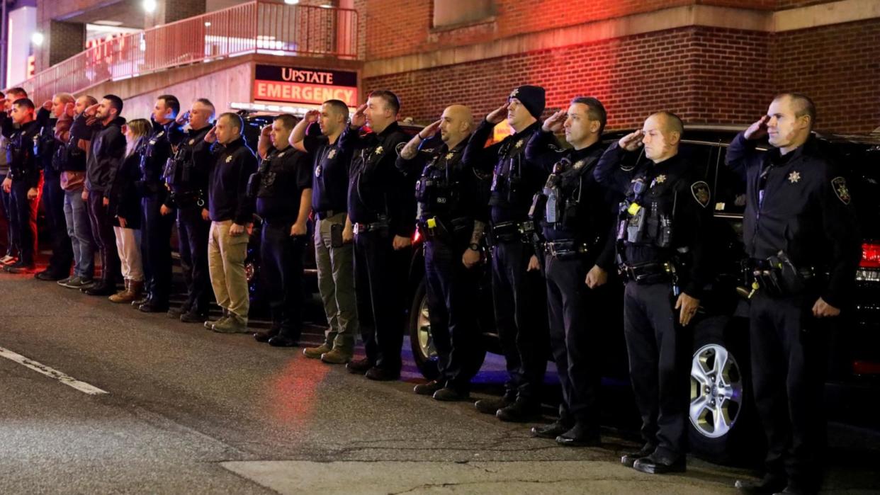 PHOTO: Law enforcement officers salute after a Syracuse police officer and an Onondaga County sheriff's deputy were shot dead in nearby Salina, outside the emergency department of SUNY Upstate University Hospital in Syracuse, N.Y., April 15, 2024.  (Caitlin Louisa Eddolls/Reuters)