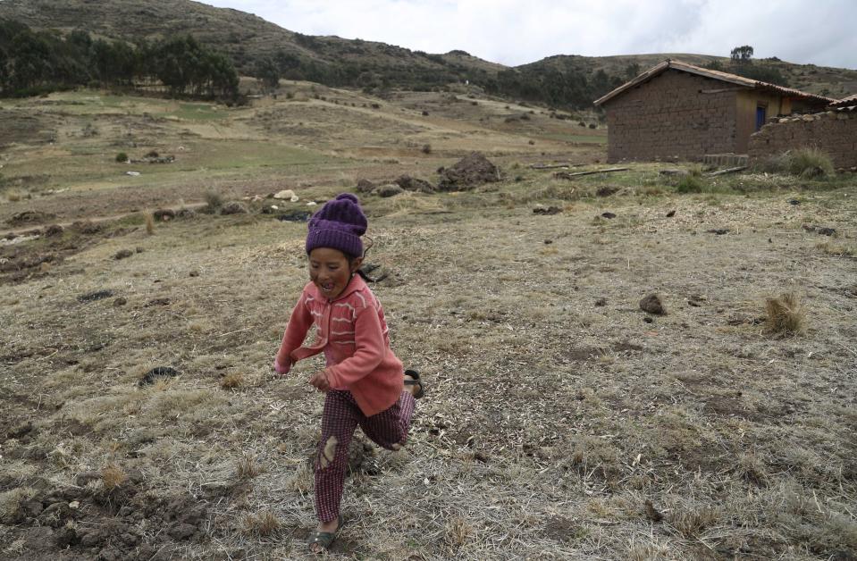 A girl runs on a field at a potato farm in Pisac, southern rural Peru, Friday, Oct. 30, 2020. Though small farmers have been somewhat shielded by the new coronavirus pandemic – many live far from other families and major cities – the recession has been costly. (AP Photo/Martin Mejia)