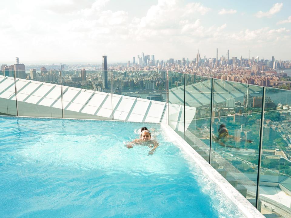 The author swims with the NYC skyline in the background.