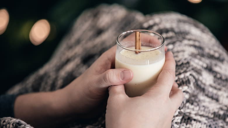 Hands holding glass of eggnog