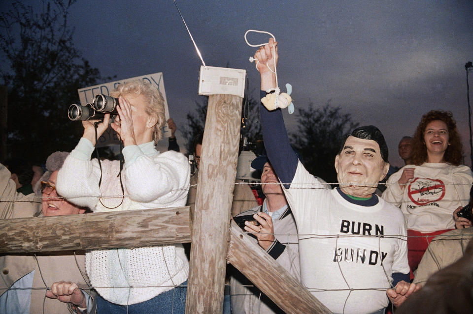 FILE - In this Jan. 25, 1989 file photo, a toy bunny is hung in effigy by Jerry Jackson of Atlanta Ga., wearing a Ronald Reagan mask, as a crowd celebrates the execution of Ted Bundy at sunrise in Starke, Fla. (AP Photo/Mark Foley)