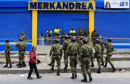 Colombian police and soldiers guard a supermarket supposedly linked to FARC in Bogota, Colombia February 21, 2018. REUTERS/Jaime Saldarriaga