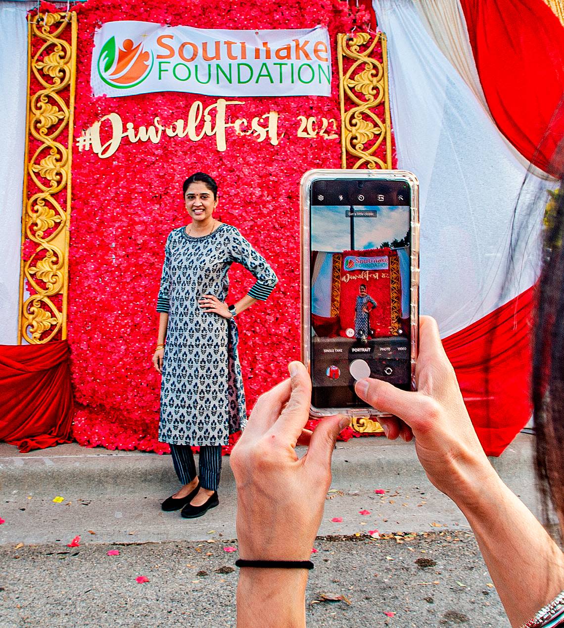 Joan Patel has a friend snap a keepsake photo of her at the Diwali celebration in Southlake, Texas, Saturday, Oct. 22, 2022.