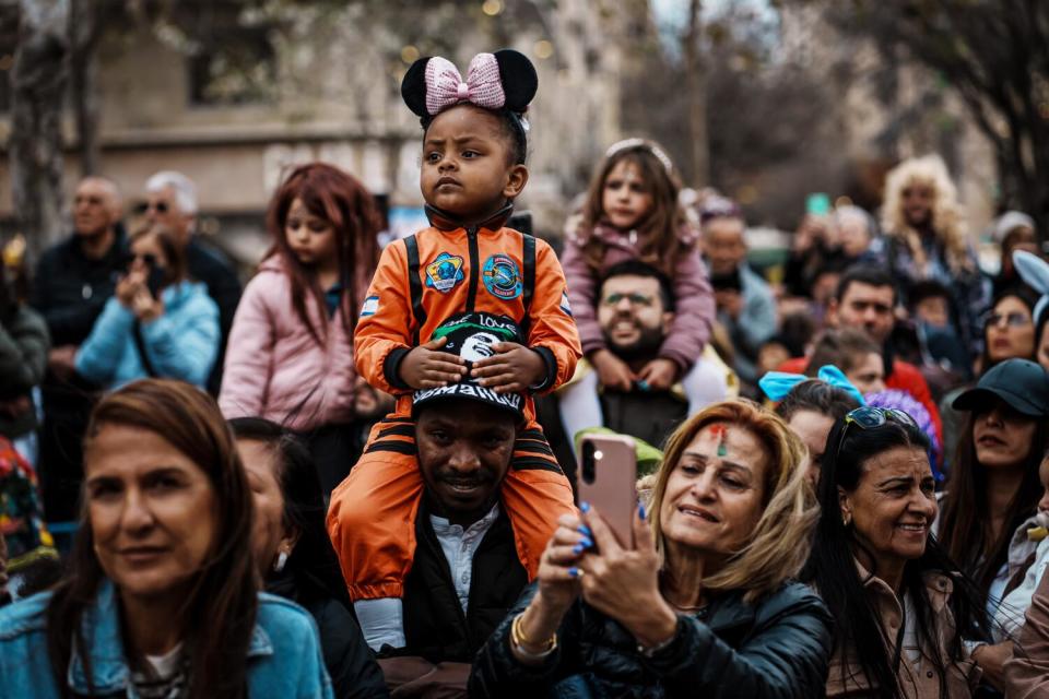 Gabriella Jember, 3, dressed as an astronaut, sits on her father's shoulders as they attend a parade in Jerusalem.