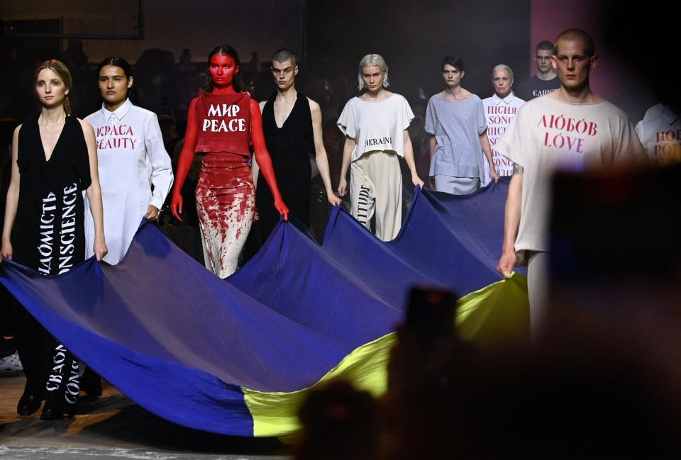 Bei der Berliner Fashion Week präsentieren Models Kreationen des ukrainischen Designers Jean Gritsfeldt und tragen dazu eine ukrainische Fahne. (Bild: Jens Kalaene/dpa-Zentralbild/dpa)