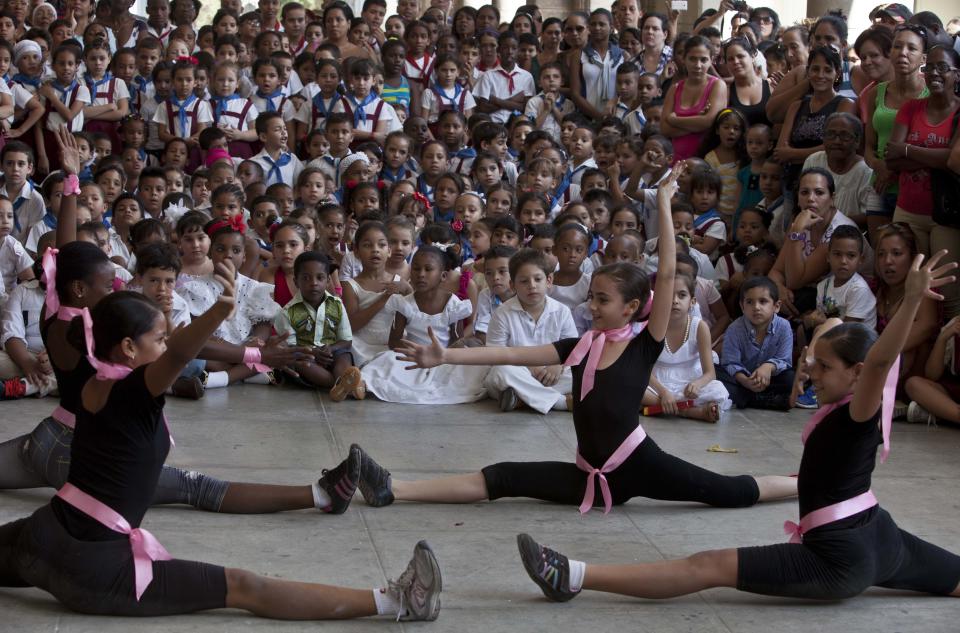 Young students perform at a celebration to mark the anniversaries of the Organization of Cuban Pioneers and of the Union of Communist Youth at the Angela Landa Elementary school in Old Havana, Cuba, Friday, April 4, 2014. Cuban schoolchildren are referred to as "pioneers," and the organization was founded in 1961 to encourage the values of education and social responsibility among children and adolescents. (AP Photo/Franklin Reyes)