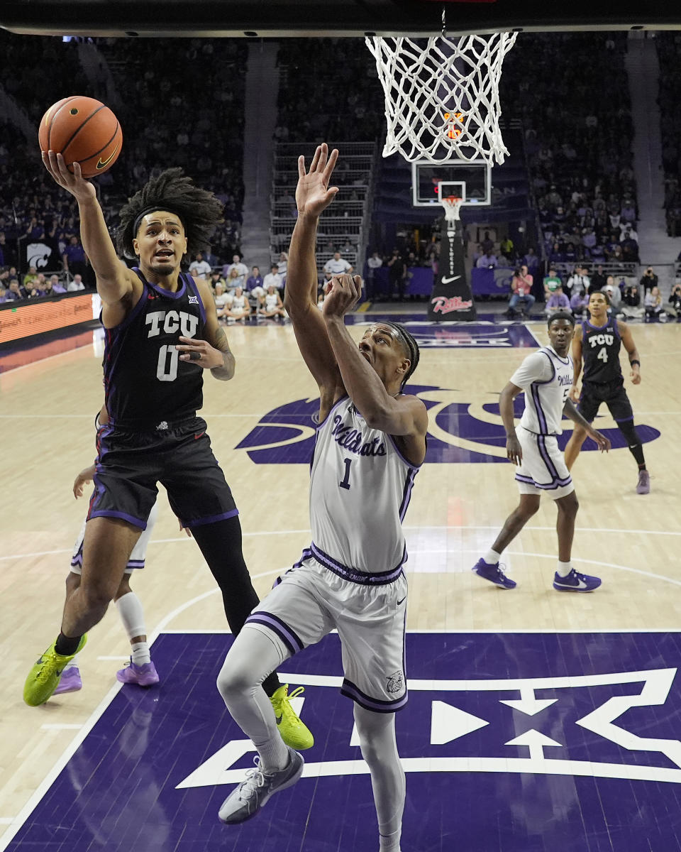 TCU guard Micah Peavy (0) gets past Kansas State forward David N'Guessan (1) to put up a shot during the first half of an NCAA college basketball game Saturday, Feb. 17, 2024, in Manhattan, Kan. (AP Photo/Charlie Riedel)