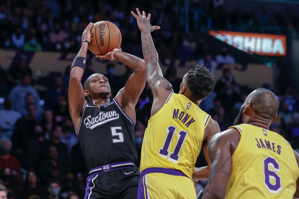 Sacramento Kings guard De'Aaron Fox (5) shoots while defended by Los Angeles Lakers guard Malik Monk (11) during the second half of an NBA basketball game in Los Angeles, Friday, Nov. 26, 2021. The Kings won 141-137 in triple overtime. (AP Photo/Ringo H.W. Chiu)