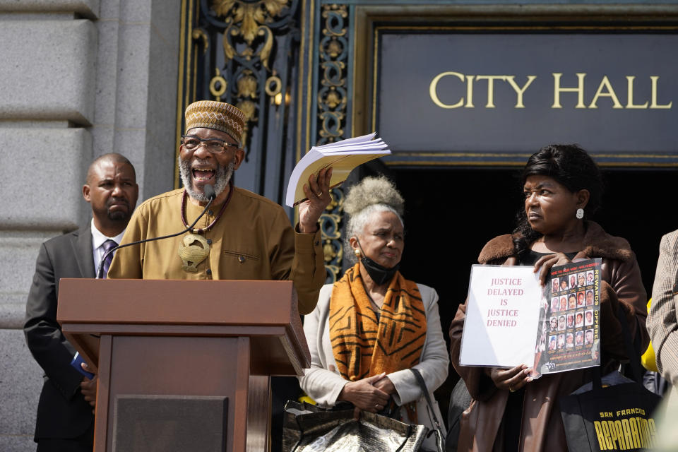 Rev. Amos Brown speaks during a rally in support of reparations for African Americans as Supervisor Shamann Walton, left, listens outside City Hall in San Francisco, Tuesday, Sept. 19, 2023. (AP Photo/Eric Risberg)