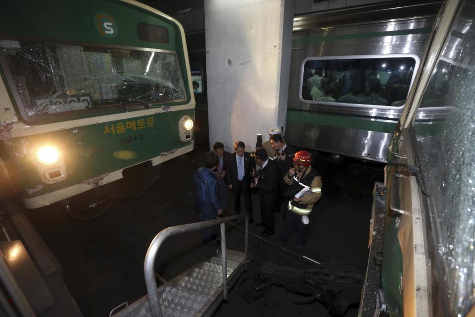 Investigators inspect the site where two subway trains collided at Sangwangshipri subway station in Seoul, South Korea, Friday, May. 2, 2014. A subway train plowed into another train stopped at the station Friday, causing minor injuries for scores of people, a city official said. (AP Photo/Yonhap, Park Dong-ju) KOREA OUT