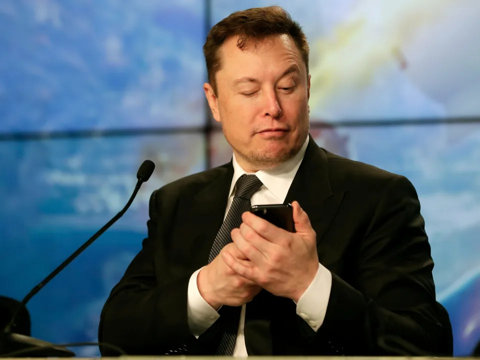 Elon Musk looking at his phone.