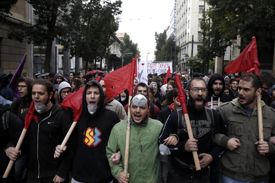 Manifestantes gritan consignas contra la visita de la caciller alemana Angela Merkel, el viernes 11 de abril de 2014, en Atenas, Grecia. (Foto AP/Petros Giannakouris)