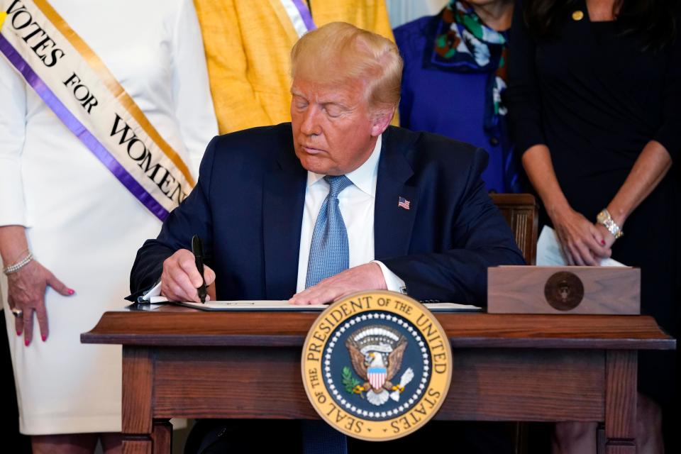 President Donald Trump signs a proclamation recognizing the 100th anniversary of the ratification of the 19th Amendment on Aug. 18 in the Blue Room of the White House in Washington.