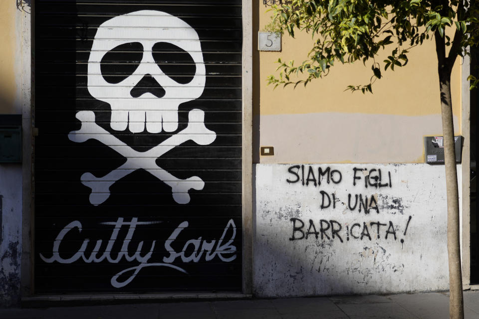 A mural posted outside the shutter of a closed pub reads, "We are the son of a barricade" in downtown Rome, Sunday, Aug. 13 ,2023. When Giorgia Meloni was running to become Italy’s first far-right head of government since the demise of the country's fascist dictatorship, she steeped her campaign in ideological touchpoints like national sovereignty and “traditional families.” (AP Photo/Gregorio Borgia)