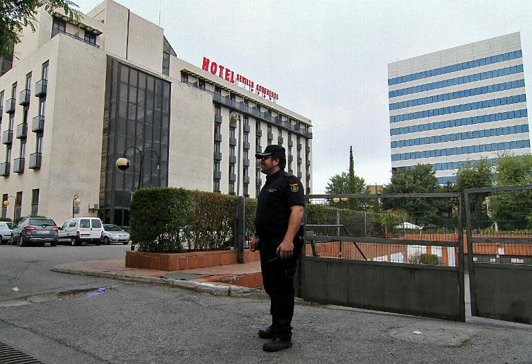 A policeman stands in front of the hotel Sevilla Congresos (L) in Sevilla on October 11, 2013 where former Spanish formula one driver Maria de Villota, 33, was found dead earlier this morning