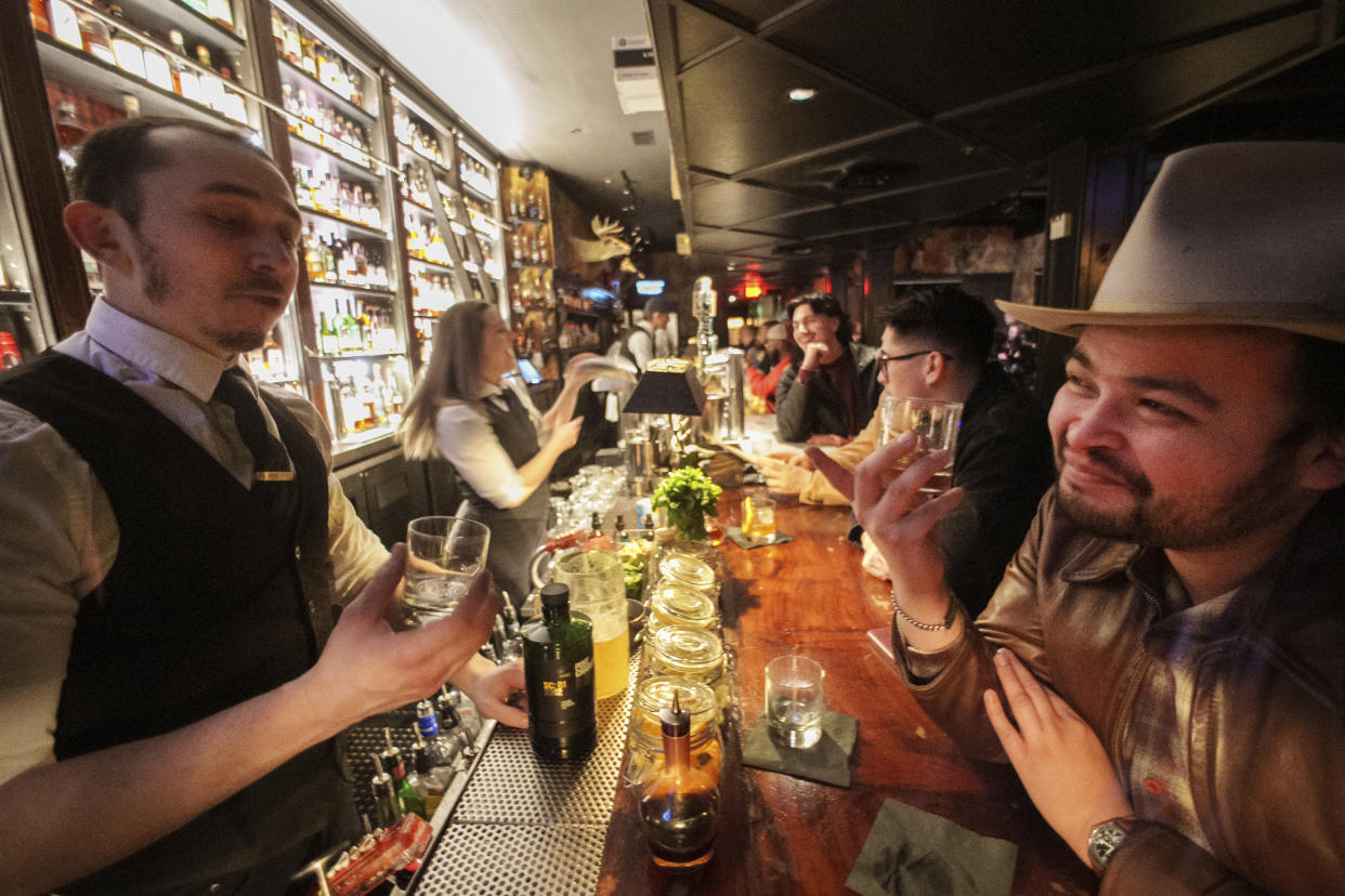 Seven Grand Bar Manager Evan Roth, left, talks to fellow bartender Roland Gonzalez, tasting bourbon at the Seven Grand bar, a whiskey bar downtown Los Angeles on Saturday, March 1, 2023. Seven Grand offers an extensive selection of over 700 different whiskies from around the world, including rare and hard-to-find bottles. Seven Grand is home to the Whiskey Society. (AP Photo/Damian Dovarganes)