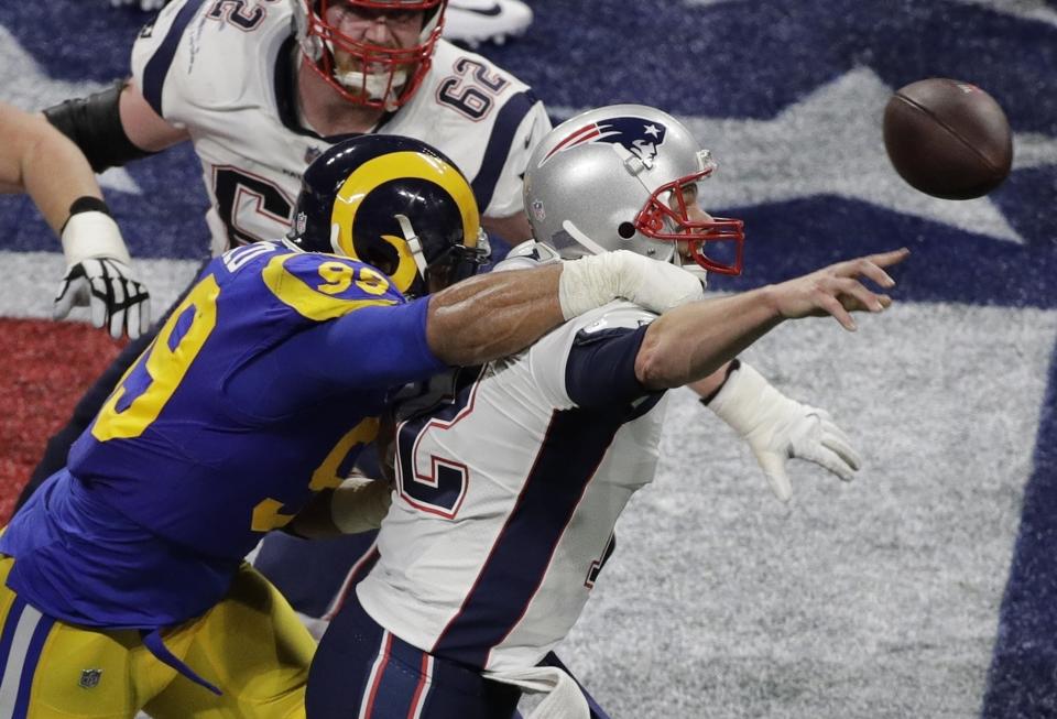 FILE - Los Angeles Rams' Aaron Donald (99) hits New England Patriots' Tom Brady (12) during the first half of the NFL Super Bowl 53 football game Sunday, Feb. 3, 2019, in Atlanta. Defensive lineman Aaron Donald has announced his retirement after a standout 10-year career with the Los Angeles Rams. The three-time AP NFL Defensive Player of the Year made his surprising announcement on social media Friday, March 15, 2024.(AP Photo/Charlie Riedel, File)