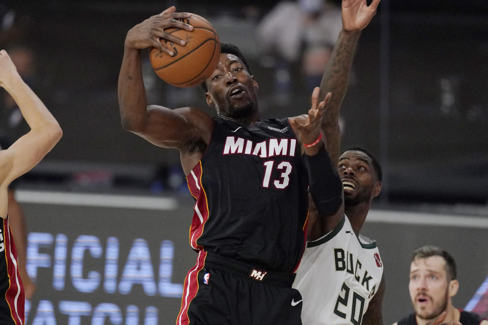 Miami Heat's Bam Adebayo (13) grabs a rebound in front of Milwaukee Bucks' Marvin Williams (20) in the second half of an NBA conference semifinal playoff basketball game Friday, Sept. 4, 2020, in Lake Buena Vista, Fla. (AP Photo/Mark J. Terrill)