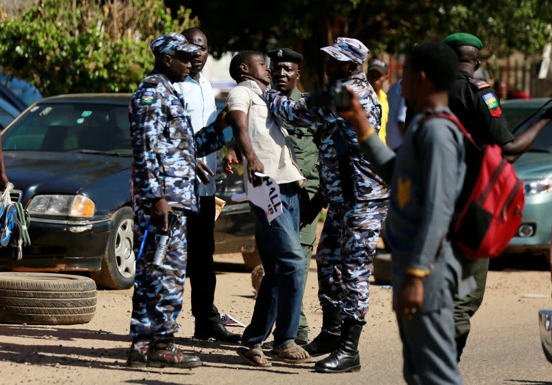 Policemen detain one of the suspected attackers of human rights activist Deji Adeyanju during a freedom rally in Abuja