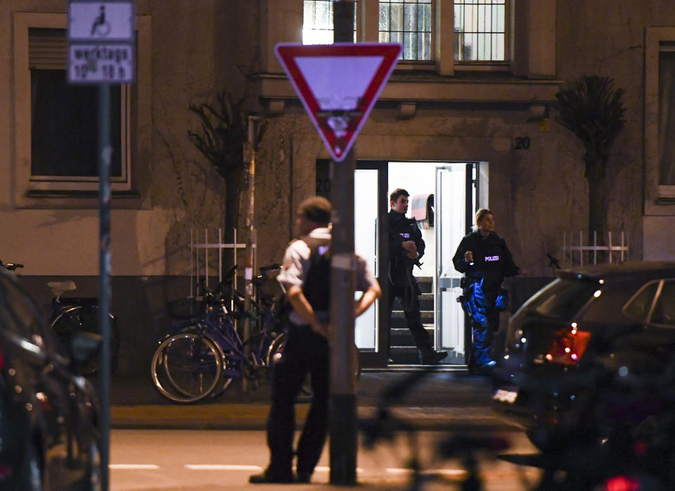 <p>Police officers are seen exiting an appartment building where investigators are searching a flat belonging to a man suspected of having driven a car into a crowd killing two and injuring several others before killing himself at a pedestrian area in Muenster, western Germany on April 7, 2018. (Photo: Patrik Stollarz/AFP/Getty Images) </p>