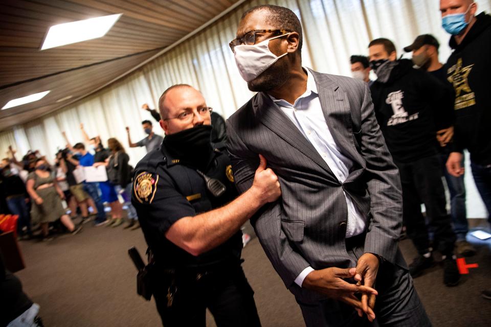 Calvin Skinner, right, is dragged out of the Main Assembly Room of the City County Building in downtown Knoxville after a group of protesters interrupted the Knox County Commission meeting on Monday, April 19, 2021.