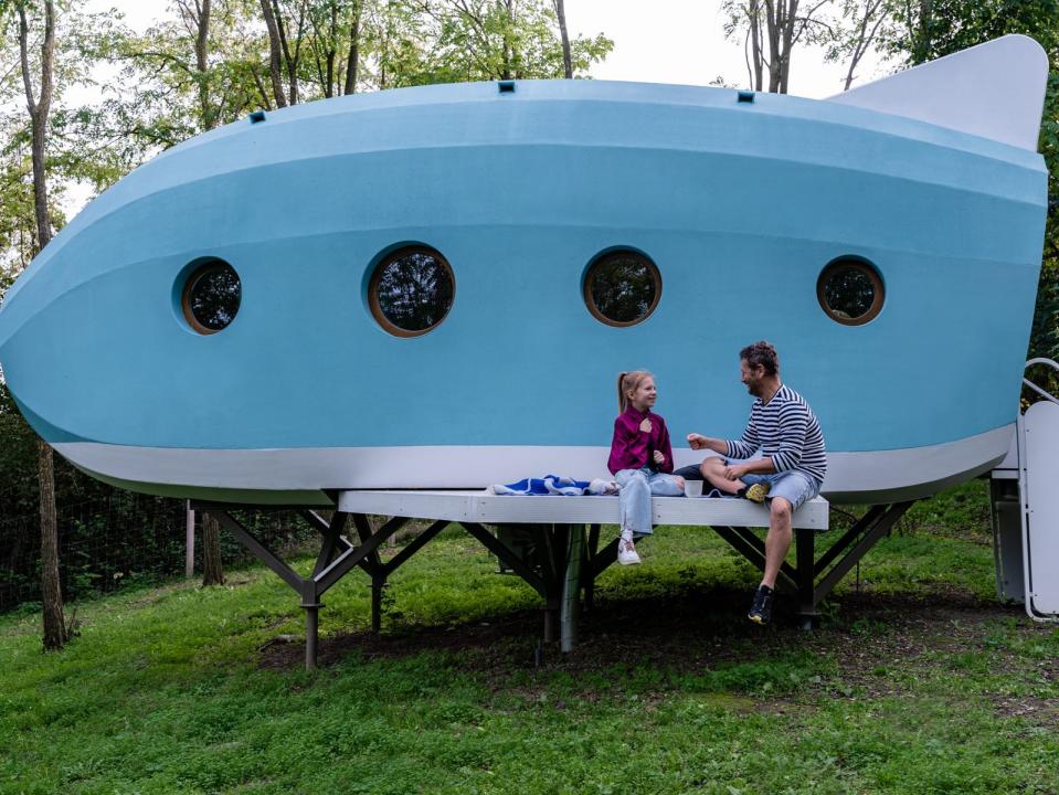 Lujzi and her father sitting outside of the Jet House.