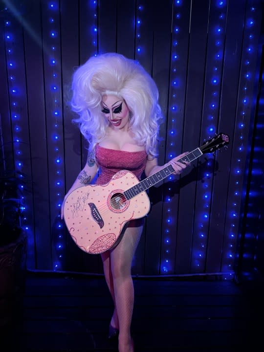 Drag performer Brigitte Bandit holds the sparkly guitar sent to her and signed by Dolly Parton. (Courtesy: Brigitte Bandit)