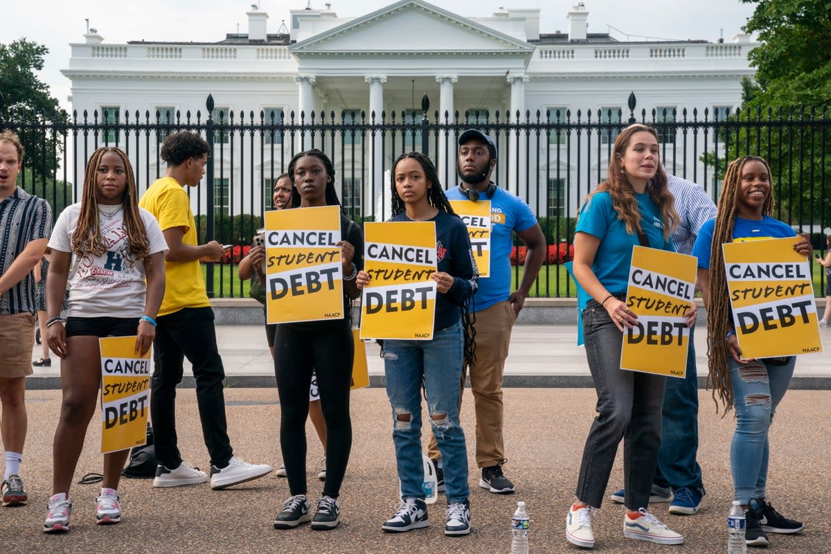 Student loan debt advocates rally outside the White House on 24 August. (EPA)