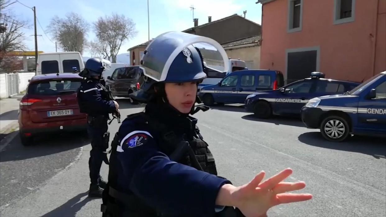 Polizisten sichern während einer Geiselnahme in einem Ort am Rande von Carcassonne eine Straße. Foto: La Depeche Du Midi