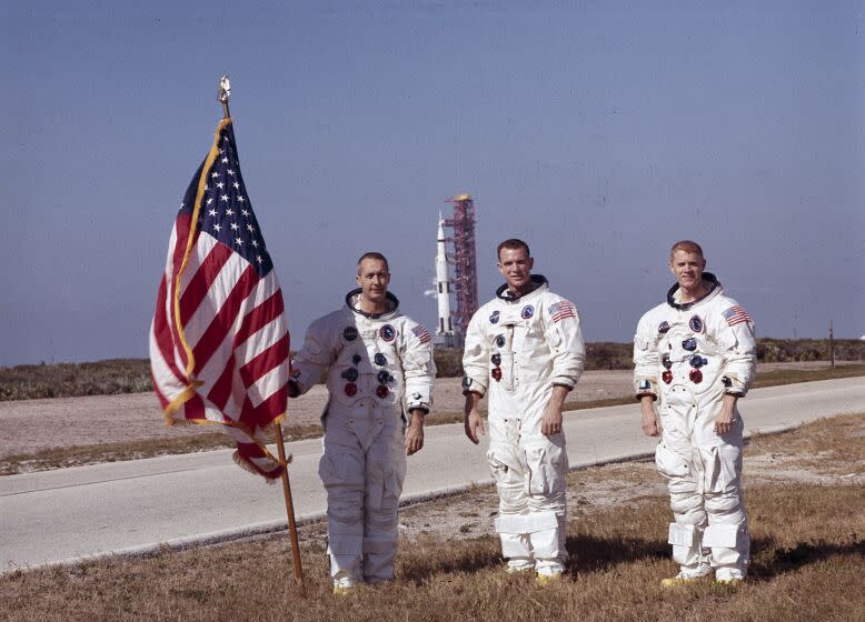 In this undated photo provided by NASA, Apollo 9 astronauts, left to right, James A. McDivitt, David R. Scott, and Russell L. Schweickart pose in front of the Apollo/Saturn V space vehicle that would launch the Apollo 8 crew. The launch of the Apollo 9 (Saturn V launch vehicle, SA-504) took place on March 3, 1969. McDivitt, who commanded the Apollo 9 mission testing the first complete set of equipment to go to the moon, died Thursday, Oct. 13, 2022. He was 93. (NASA via AP)