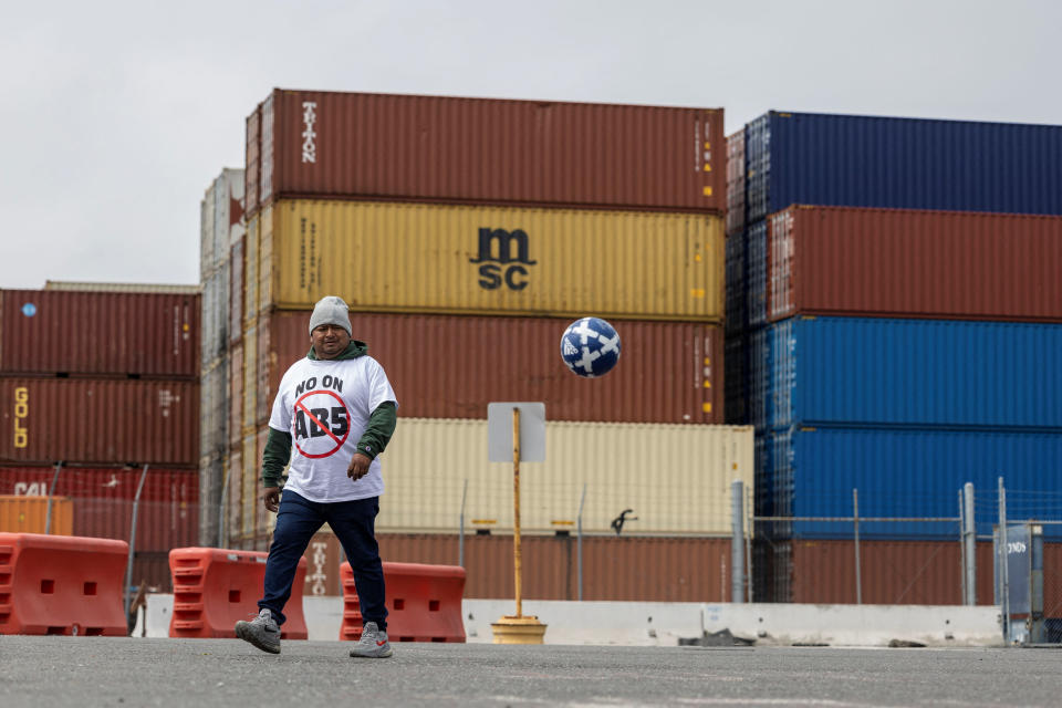 A truck driver plays soccer as he joins a gathering to block the entrance of trucks at a container terminal at the Port of Oakland, during a protest against California's law known as AB5, in Oakland, California, July 21, 2022. REUTERS/Carlos Barria