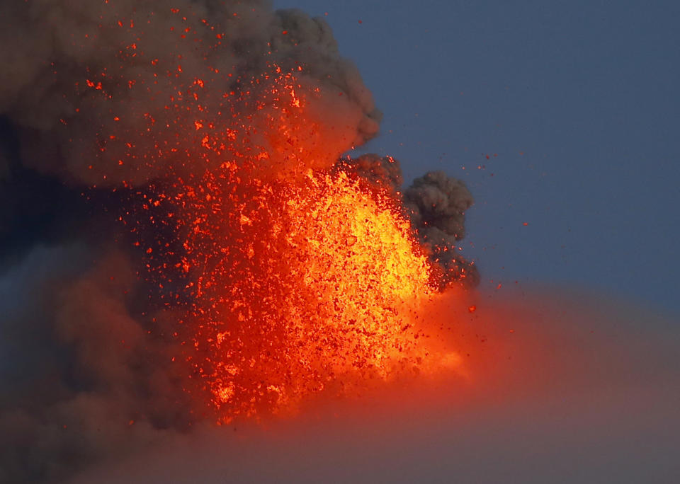 FILE - In this Jan. 24, 2018, file photo, Mayon volcano spews red-hot lava in another eruption as seen from Legazpi city, Albay province, around 340 kilometers (200 miles) southeast of Manila, Philippines. (AP Photo/Bullit Marquez, File)