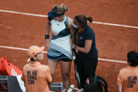 Spain's Paula Badosa gets medical assistance prior to retiring from the race during her third round match against Russia's Veronika Kudermetova at the French Open tennis tournament in Roland Garros stadium in Paris, France, Saturday, May 28, 2022. (AP Photo/Thibault Camus)