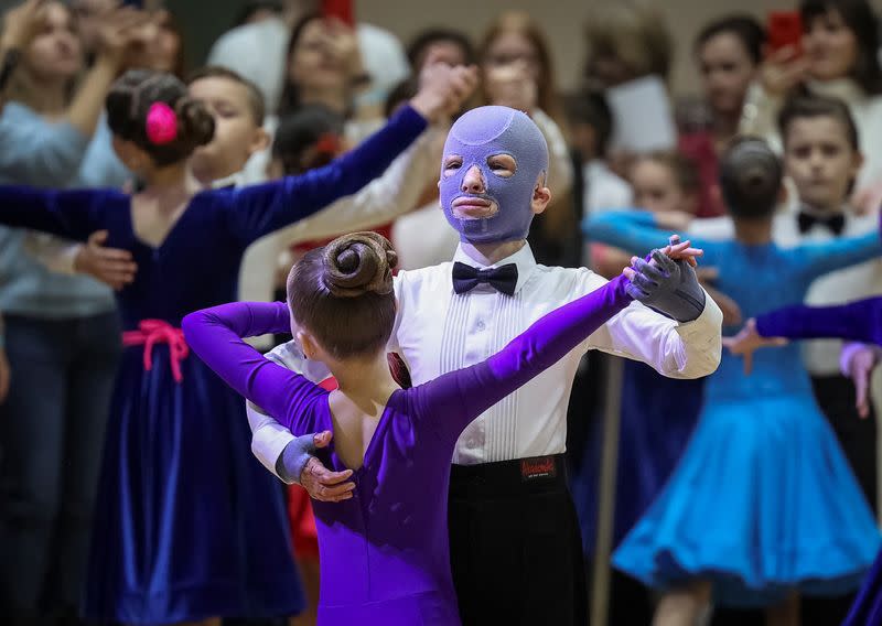 Roman, wounded by Russian missile strike last year, wears a burn mask as he takes part in a ballroom dance competition, in Lviv